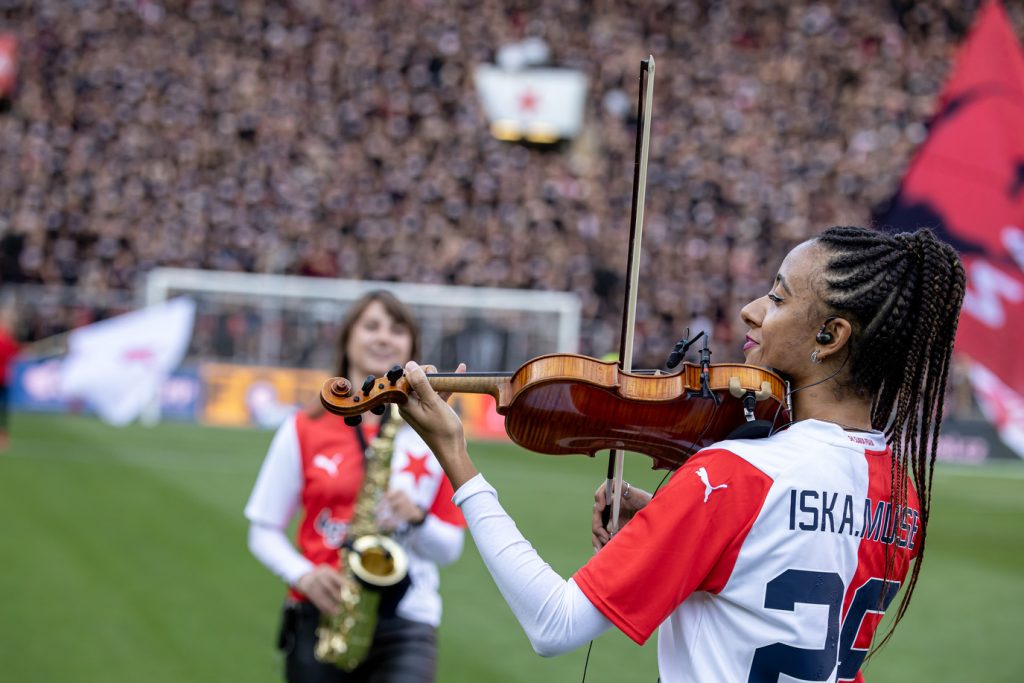 Houslistka Iska.muse a saxofonista hrají na stadionu Eden v Praze před derby Slavia–Sparta